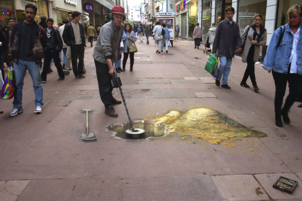Sidewalk drawing of the artist Julian Beever testing with his metal detector the inside of a hole getting bigger