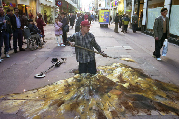 3D chalk illusion of the artist Julian Beever digging with a big heap of earth around him