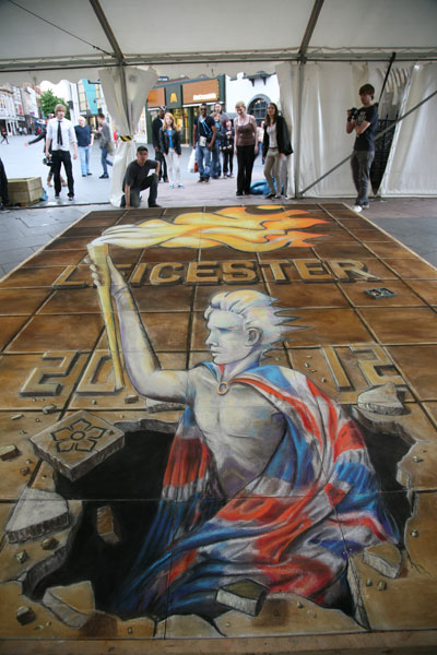 3D pavement drawing of an athlete holding the olympic torch