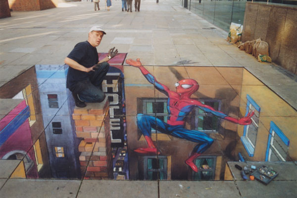 3D chalk drawing of Spiderman coming to the rescue of the real artist posing on top of a very high chimney (also drawn)