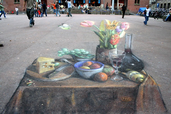 3D pavement drawing of a table with cheese, fruit, wine and flowers