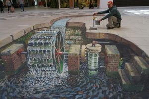 Sidewalk art showing a watermill bringing water to a water fountain